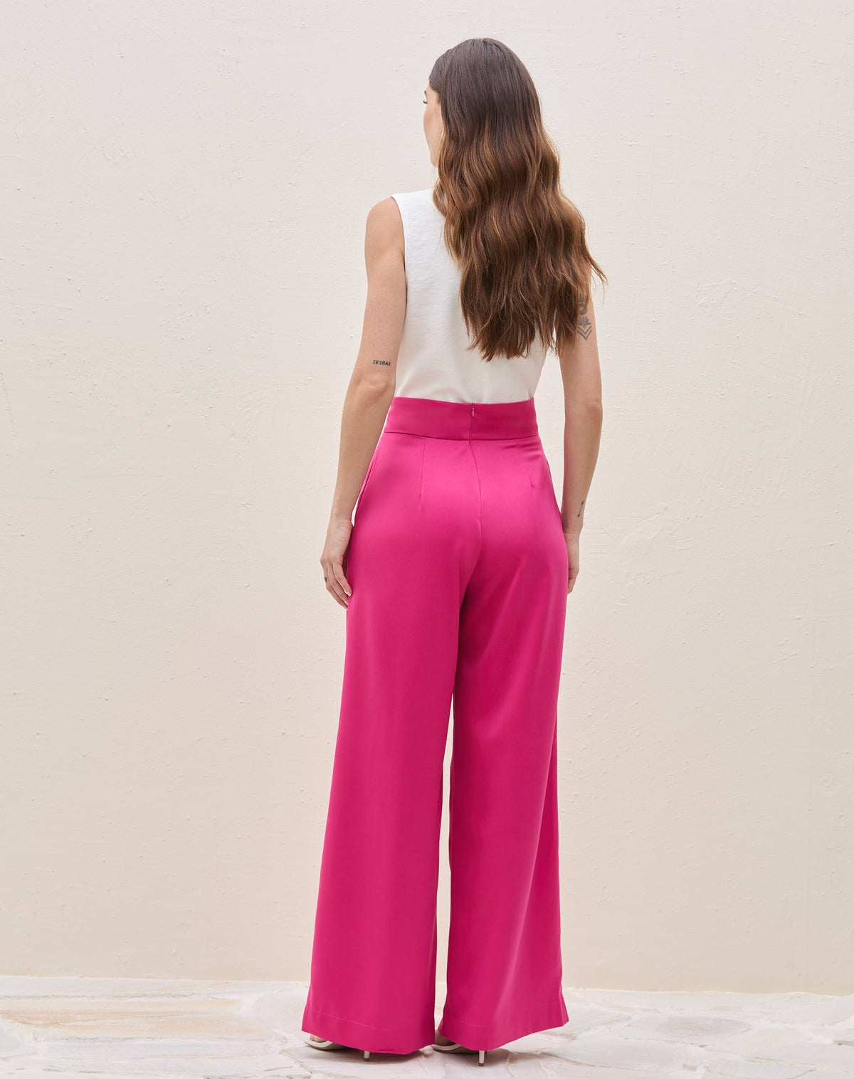 Vista traseira da calça wide leg rosa escuro com pregas.