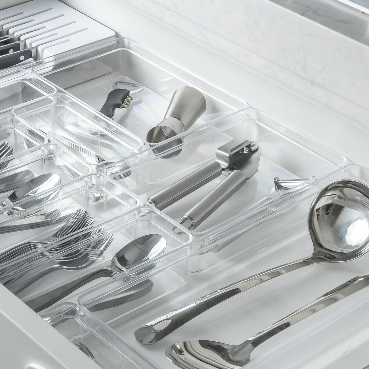 organizadores de gavetas com utensílios de cozinha dentro da gaveta aberta