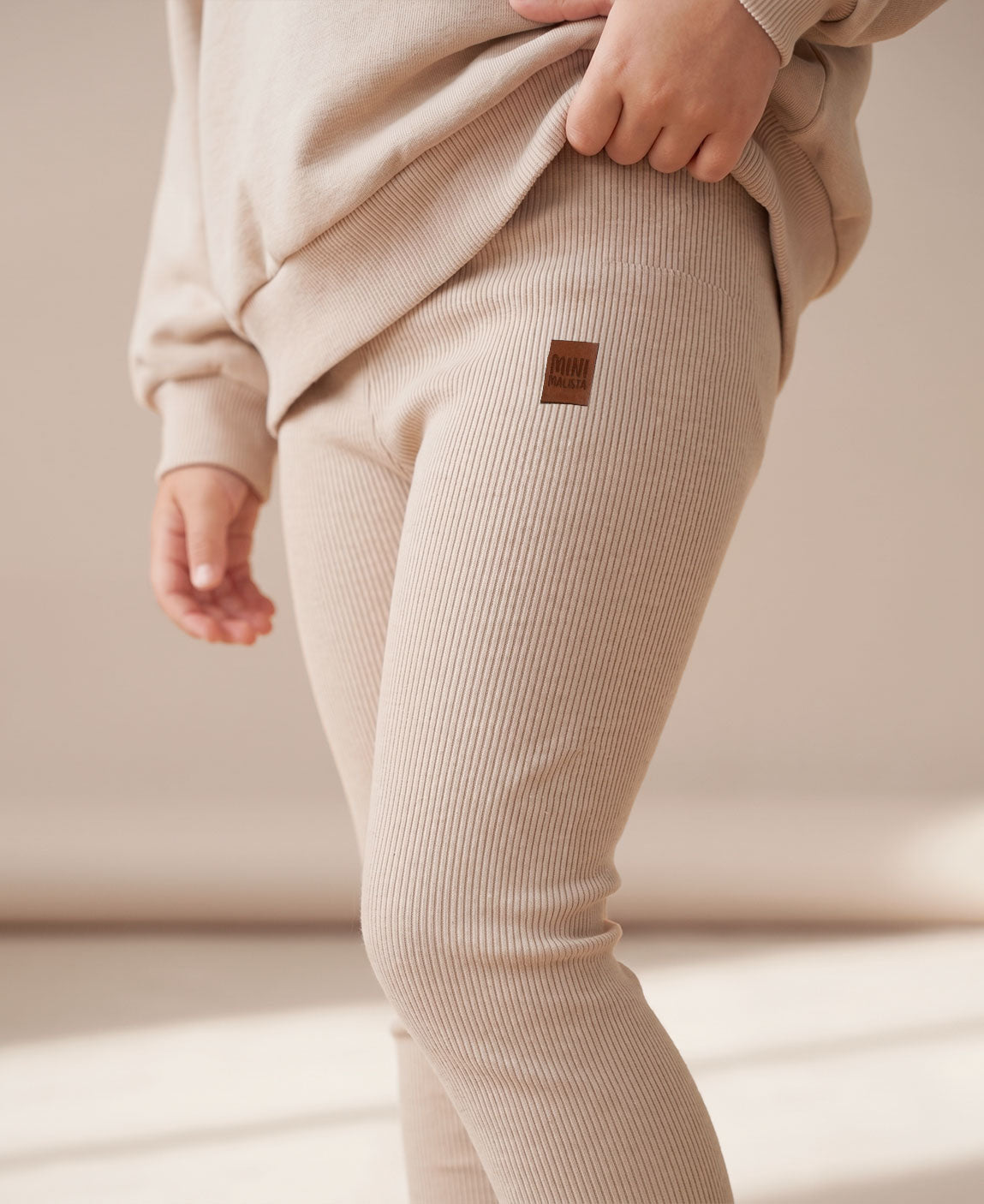 MiniMalista Conjunto Moletom + Calça Canelada Liso Bege Claro vista frontal. Look monocromático infantil 100% algodão, moletom peluciado oversized + calça canelada slim ajustada, conjunto unissex menino e menina para bebê e criança, do bebê de 0-3 meses aos 5-6 anos.