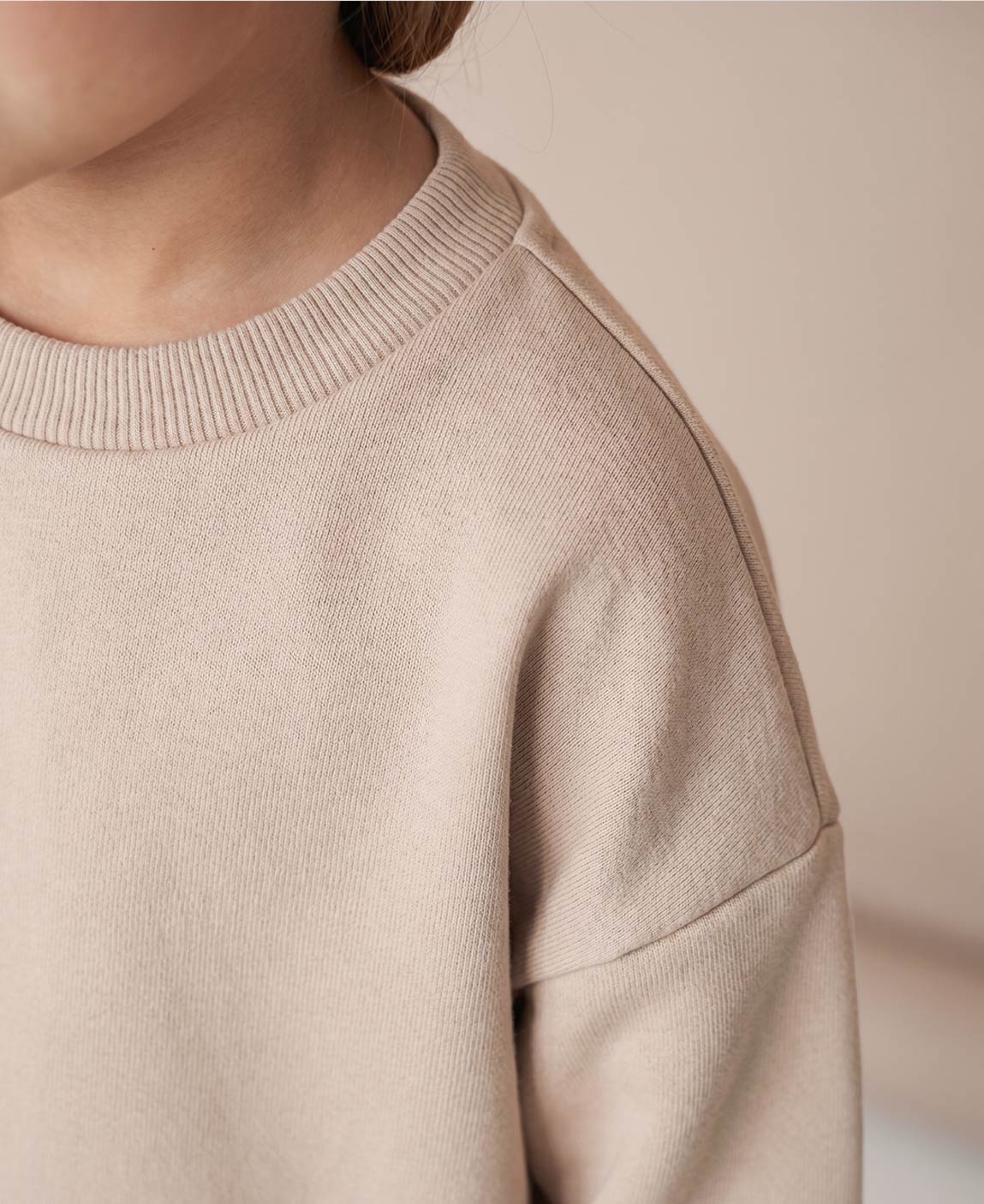 MiniMalista Conjunto Moletom + Calça Canelada Liso Bege Claro vestido em criança. Look elegante e atemporal infantil 100% algodão, moletom peluciado e calça canelada slim no mesmo tom bege coringa, conjunto unissex menino e menina.