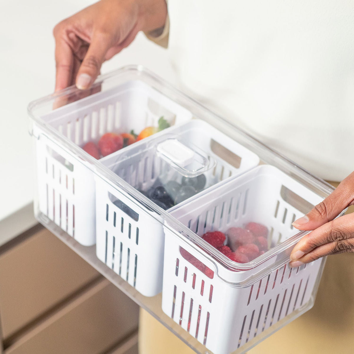 organizador de geladeira com frutas dentro sendo carregado